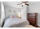 Bedroom with ceiling fan, closet, and dresser with warm decor at 1659 Beecher Sw St, Atlanta, GA 30310