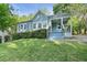 Charming light-blue house with a well-maintained lawn and inviting front porch, surrounded by lush greenery and mature trees at 1659 Beecher Sw St, Atlanta, GA 30310
