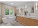 Bright bathroom boasts dual vanity, freestanding tub, and a window overlooking the landscape at 4067 Randall Farm Se Rd, Atlanta, GA 30339