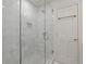 Marble tiled walk-in shower featuring glass doors and modern fixtures at 4067 Randall Farm Se Rd, Atlanta, GA 30339