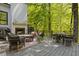 Cozy outdoor patio with fireplace, dining area, and scenic views of the surrounding greenery at 4067 Randall Farm Se Rd, Atlanta, GA 30339