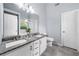 Bright bathroom featuring granite countertops, white cabinets, and gray wood-look tile flooring at 823 Langley View Ct, Loganville, GA 30052