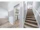 Hallway featuring a staircase, door to the laundry room with visible washer and dryer, and wood-look flooring at 823 Langley View Ct, Loganville, GA 30052