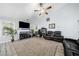 Spacious living room with fireplace, vaulted ceilings, ceiling fan, gray wood-look flooring and black leather furniture at 823 Langley View Ct, Loganville, GA 30052