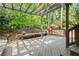 Spacious wooden back deck with pergola, benches, grill and wooded view at 11060 Pennbrooke Xing, Johns Creek, GA 30097