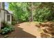 Backyard view of the home, set amongst mature trees and landscaping at 11060 Pennbrooke Xing, Johns Creek, GA 30097