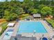 Aerial view of large community pool with ample seating and a splash pad with nearby playground enhancing outdoor activities at 11060 Pennbrooke Xing, Johns Creek, GA 30097