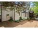Exterior back view featuring lush landscaping and a screen porch at 11060 Pennbrooke Xing, Johns Creek, GA 30097