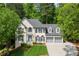 Charming home featuring a three-car garage, lush landscaping, and a welcoming front entrance, perfect for suburban living at 11060 Pennbrooke Xing, Johns Creek, GA 30097