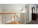 Upstairs hallway with wood railing, window, and view into the living area at 11060 Pennbrooke Xing, Johns Creek, GA 30097