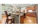 Kitchen island with bar stool seating, granite countertops, view to breakfast nook and staircase at 11060 Pennbrooke Xing, Johns Creek, GA 30097