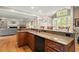 Kitchen island with granite countertops, bar seating, and an open view to living area at 11060 Pennbrooke Xing, Johns Creek, GA 30097