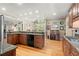 Kitchen with hardwood floors, granite countertops, wood cabinetry, and view to breakfast nook at 11060 Pennbrooke Xing, Johns Creek, GA 30097