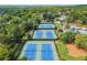 Overhead view of well-maintained tennis courts and adjacent pool surrounded by lush greenery creating a vibrant athletic community at 11060 Pennbrooke Xing, Johns Creek, GA 30097