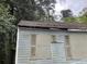 Exterior view shows boarded up windows and overgrown vegetation at 1254 Campbellton Sw Rd, Atlanta, GA 30310