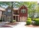 Two-story townhome featuring a brick facade, attached garage and manicured landscaping at 1396 Dolcetto Nw Trce # 12, Kennesaw, GA 30152