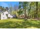 Large, green backyard with mature trees, a home, and a play area, perfect for Gathering fun and outdoor activities at 257 Browning Cir, Acworth, GA 30101