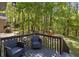 Outdoor deck featuring comfortable seating with a lovely view of the surrounding trees and backyard play area at 257 Browning Cir, Acworth, GA 30101