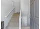 Bright entryway with a carpeted staircase, white railing, and a door to a lower level at 257 Browning Cir, Acworth, GA 30101