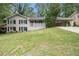 Charming two-story home featuring a spacious front yard, carport, and a welcoming red front door at 3500 Finesse Dr, Decatur, GA 30032