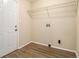 Practical laundry room with a wire shelf, washer/dryer hookups, and vinyl wood plank flooring at 3500 Finesse Dr, Decatur, GA 30032