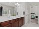 Bathroom with a double sink vanity, large mirror, shower with glass door, and view into the bedroom at 4150 Spring Ridge Dr, Cumming, GA 30028