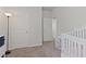Bedroom space featuring a crib, neutral colors, and a view into the hallway at 4150 Spring Ridge Dr, Cumming, GA 30028