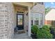 Close-up of a welcoming front door with a charming brick surround and decorative plants at 4150 Spring Ridge Dr, Cumming, GA 30028