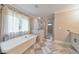 A luxurious bathroom featuring a freestanding soaking tub, a shower, and neutral decor at 1026 Towne Mill Xing, Canton, GA 30114