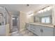 Bright bathroom featuring double vanity with grey cabinets, large mirror, and glass-enclosed shower at 1026 Towne Mill Xing, Canton, GA 30114