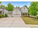 Charming two-story home featuring a three-car garage, manicured lawn, and beautiful landscaping at 1026 Towne Mill Xing, Canton, GA 30114