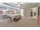 Large main bedroom with tray ceilings, a ceiling fan, and access to a bathroom and laundry room at 1026 Towne Mill Xing, Canton, GA 30114