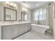 Bathroom showcases a luxurious soaking tub, dual vanities, and elegant fixtures with natural light at 215 Arizona Ne Ave # 6, Atlanta, GA 30307