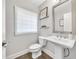Stylish powder room with a pedestal sink, modern fixtures, and a window for natural light at 215 Arizona Ne Ave # 6, Atlanta, GA 30307