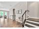 Spacious foyer with hardwood floors, a bench with throw pillows, and a staircase with modern railings at 215 Arizona Ne Ave # 6, Atlanta, GA 30307