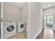 Bright laundry room features modern washer and dryer with wood-look tile and easy access to the main bedroom at 215 Arizona Ne Ave # 6, Atlanta, GA 30307