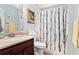 Cozy bathroom featuring a modern vanity with a sink, toilet, and a shower with a stylish black-and-white shower curtain at 65 Macadamia Ct, Covington, GA 30016