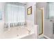 Bathroom with a large tub, a separate shower, and a window at 65 Macadamia Ct, Covington, GA 30016