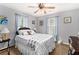 Bedroom featuring a soft color scheme, a ceiling fan, and two windows at 65 Macadamia Ct, Covington, GA 30016