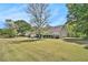 Spacious front yard of a single-story home showcasing mature trees and landscaping at 65 Macadamia Ct, Covington, GA 30016