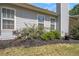 Landscaped home exterior featuring blossoming red roses along the side of the house, adding a touch of natural beauty to the property at 65 Macadamia Ct, Covington, GA 30016
