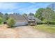 Exterior view of the single-story home featuring an attached two-car garage and a lush front yard at 65 Macadamia Ct, Covington, GA 30016
