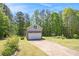 Detached two-story garage with stone accents and a long driveway, offering ample parking and storage at 65 Macadamia Ct, Covington, GA 30016