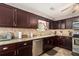 A kitchen with dark cabinets, stainless steel appliances, and granite countertops, giving it a modern touch at 65 Macadamia Ct, Covington, GA 30016
