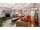 Cozy living room with fireplace, tray ceilings, hardwood floors and comfortable seating at 65 Macadamia Ct, Covington, GA 30016