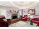 Inviting living room featuring a stone fireplace, tray ceilings, hardwood floors, and comfortable seating at 65 Macadamia Ct, Covington, GA 30016