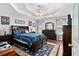 A spacious main bedroom with dark wood furniture, a trey ceiling and hardwood floors at 65 Macadamia Ct, Covington, GA 30016