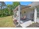 Covered outdoor patio with patio table, seating, and a manicured lawn, perfect for outdoor relaxation and entertaining at 65 Macadamia Ct, Covington, GA 30016