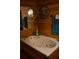 Relaxing bathroom showcases a jetted tub with wood paneling, enhanced by rustic decor and warm lighting at 6503 Old Macon Hwy, Rex, GA 30273