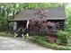 A charming log cabin with a cozy front porch, complemented by a beautiful tree and landscaped yard at 6503 Old Macon Hwy, Rex, GA 30273